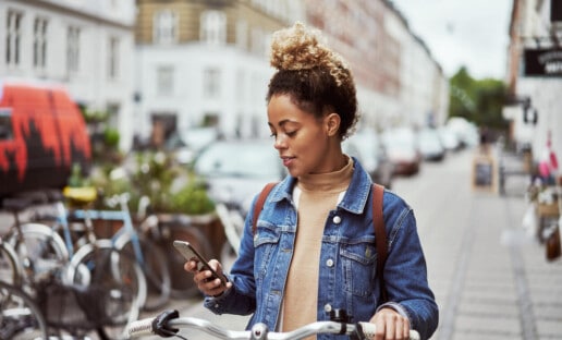 girl on bike looking at smart phone