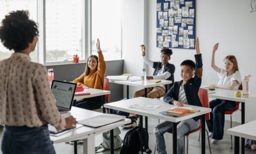 teacher taking quiz with children raising hands to show a high survey response rate